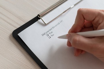 Unrecognizable woman puts a daw in the questionnaire. A close-up of a female hand answering about a...