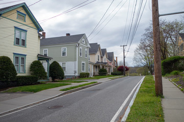Fototapeta na wymiar row of homes on a quite suburban street road wth sidewalks and spring budding streets