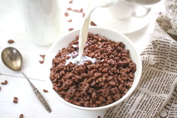 Milk is poured into chocolate balls.
Breakfast cereal