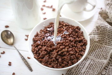 Milk is poured into chocolate balls.
Breakfast cereal