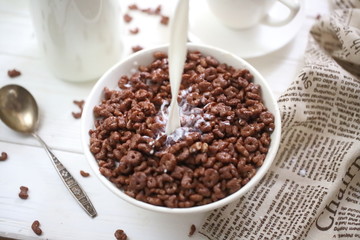 Milk is poured into chocolate balls.
Breakfast cereal