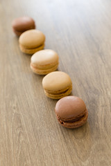 Fototapeta na wymiar Colorful macarons in brown and earth colors. Sweet French cakes.