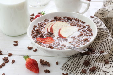 Milk is poured into chocolate balls.
Breakfast cereal