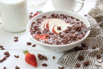 Milk is poured into chocolate balls.
Breakfast cereal