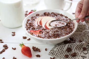 Milk is poured into chocolate balls.
Breakfast cereal