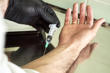 gloved doctor gives an injection to a patient