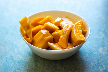 Cut mangoes in white bowl