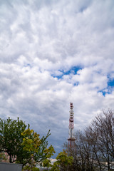 Telecommunication tower on cloud sky background