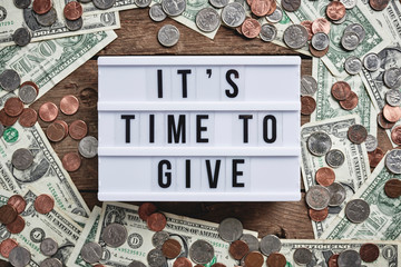 a sign that reads, "it's time to give" surrounded by money.