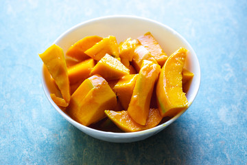 Cut mangoes in white bowl