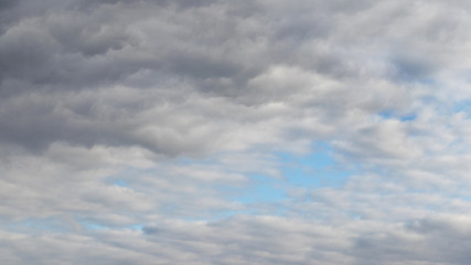 Thick gray clouds, through which you can see a piece of blue sky