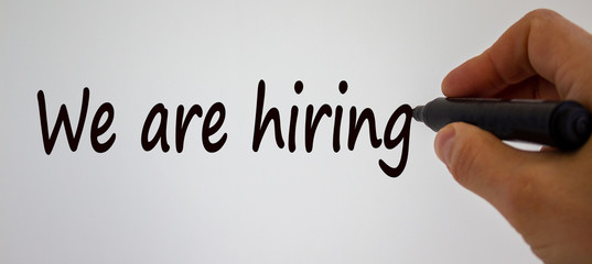 Hand writing 'we are hiring', isolated on white background.
