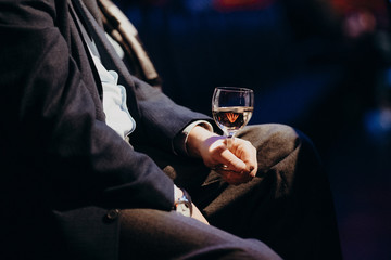 man holding wine glass in concert hall