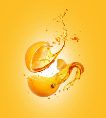 Juice splashes out from sliced orange on a yellow background © Krafla