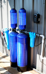 Whole house water filter - Modern reverse osmosis system outdoors on metal wall background.