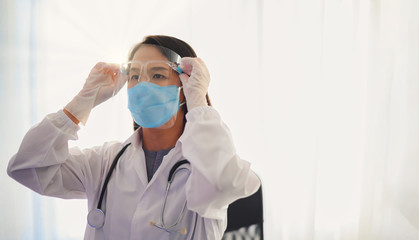 Fototapeta na wymiar Doctor preparing for the surgical operation and wearing protective glasses for Fighting Covid-19 (Corona virus) with white background Coronavirus outbreak or Covid-19, Concept of Covid-19 quarantine