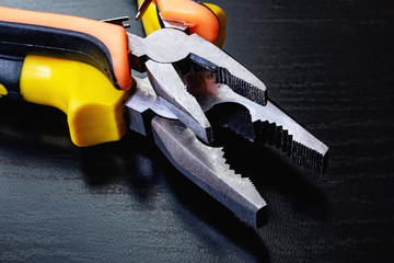 Two pliers, tools on a wooden table