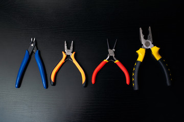 Pliers, tools on wooden table close up