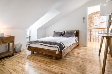 Hotelroom with a wooden bed and premium linen