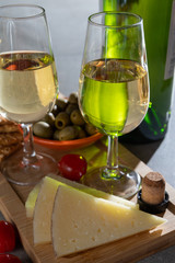 Glasses of dry fino sherry wine served with spanish tapas, manchego cheese, green olives, cheese crackers