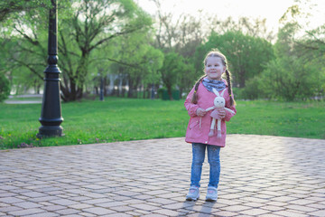 little girl outdoors alone with a toy, without parents, social