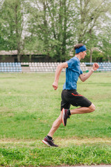 Obraz premium young guy runs morning stadium workout