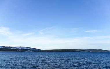 Non-freezing lake on the Kola Peninsula on a sunny winter day.