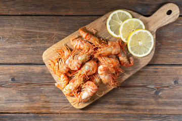 Shrimp on a wooden Board on a brown wooden table. Greenlandic prawns