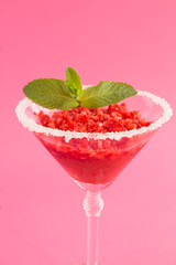Frozen juice with strawberry in a one martini glass  on the pink background. Location vertical. Closeup.
