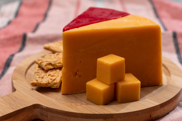 Matured yellow and red waxed cheddar cheese close up