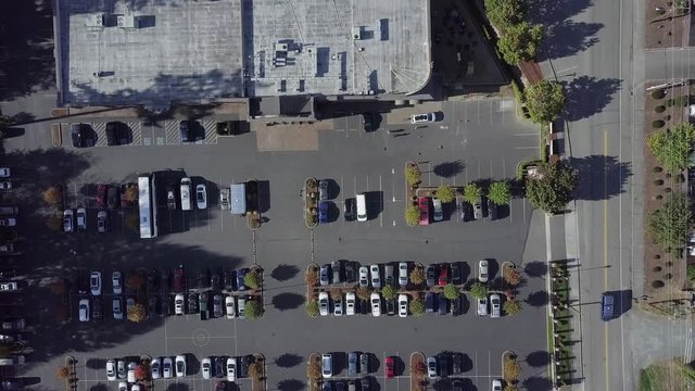 4K. Top view of various cars parked in a modern city in front of a store. Concept of automobile traffic and Parking .