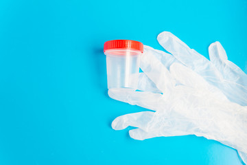 Flat lay of the medical latex gloves and empty plastic test container with copy space