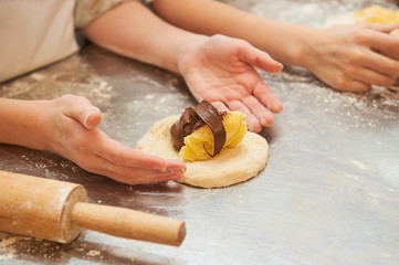 young children fill a flour product with a sweet filling. Master class baking