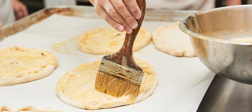 Small Children Grease A Dough Product With An Egg. Holding A Brush