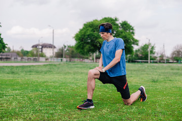 young guy does warm-up at the stadium before running