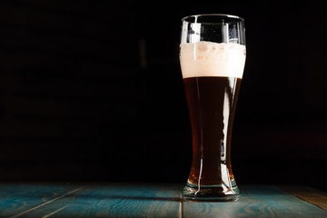 Poured beer on a dark background on a wooden table. The concept of relaxation and pastime