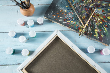 canvases and gouache with brushes on table