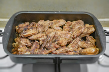 Fresh appetizing chicken wings fried on a kitchen gas stove