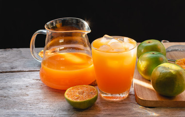 Glass and Orange juice pitcher with oranges on the black wooden background, A refreshing drink Sweet taste from natural fruit High vitamin C. Helps the digestive system and nourishes the skin.
