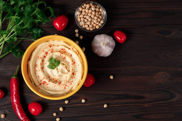 Plate of traditional chickpea hummus on a wooden background