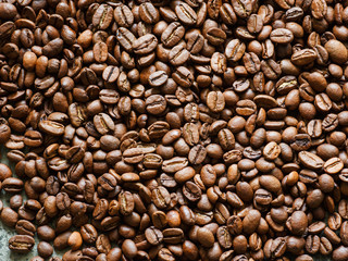 Lots of brown coffee beans, close-up. There is a place for the text.