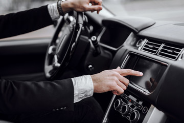 Businessman touching screen in modern car dashboard