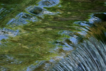 Little creek with waterfalls in green nature