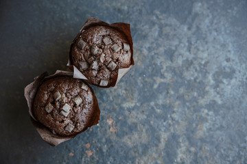 Chocolate muffins vintage background, selective focus. Top view on homemade chocolate cupcakes 