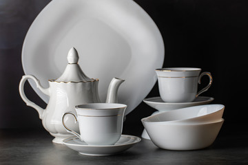 White porcelain tea set-folded cups and saucers and teapot.