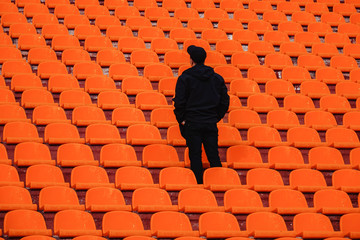 the guy in black stands alone in the orange stands