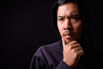 Fototapeta premium Face of stressed young Asian man in hoodie thinking