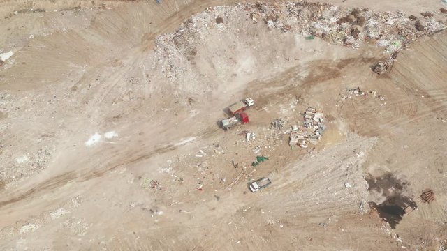 Flying over the garbage dump. A global catastrophe in the world, cars take out garbage to a landfill.