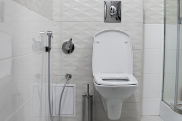 White toilet bowl in modern light bathroom interior.