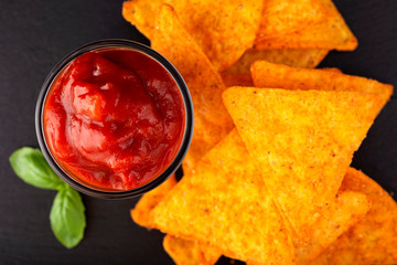 Tortilla chips and one glass bowl filled with salsa sauce